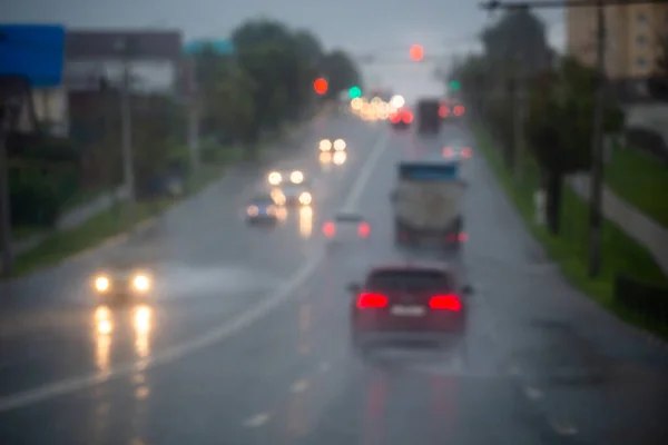 Photo déconcentrée de la circulation de voitures de rue du soir après la pluie - vue depuis la route. — Photo