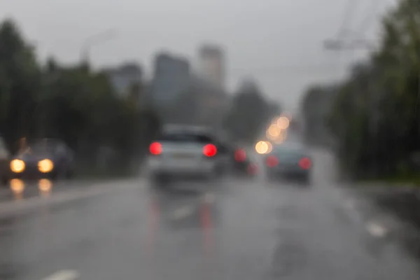 Photo déconcentrée de la circulation de voitures de rue du soir après la pluie - vue depuis la route. — Photo