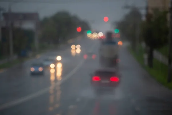 Photo déconcentrée de la circulation de voitures de rue du soir après la pluie - vue depuis la route. — Photo