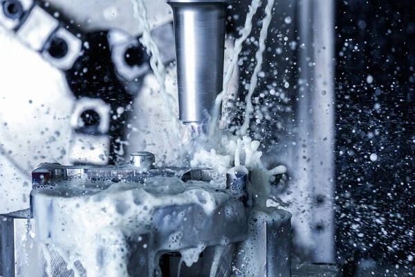 Um processo de moagem de aço cnc vertical com correntes de refrigeração de água externas e salpicos — Fotografia de Stock