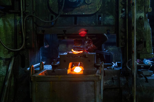 крупным планом свежие кованые горячие стальные детали после формирования пресса на грязной темной фабрике