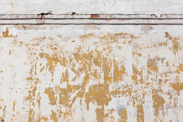 Обветшалая плоская штукатурка и окрашенная стена с большими желтыми пятнами под слоем — стоковое фото