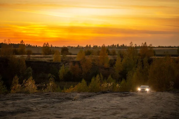 VOLKOVO, RUSSIA - PAŹDZIERNIK 4, 2020: Niebieski Nissan Qashqai wspina się po polnej drodze jesienią złoty zachód słońca froad. — Zdjęcie stockowe