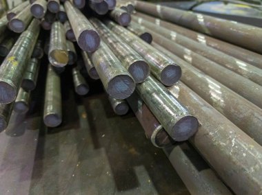 raw stainless steel rods storage - closeup with selective focus and background blur clipart