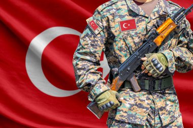 Turkey flag with soldier in military uniform holding assault rifle in front of it