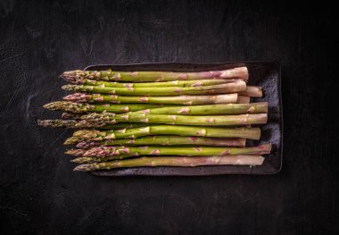 Siyah arka planda taze yeşil kuşkonmaz