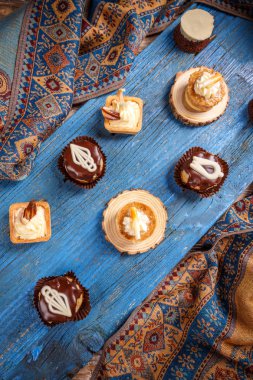 Bir mavi ahşap tahta üzerinde duran farklı küçük kek