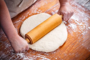 Erkek mutfak masasının üstünde dışarı hamur haddeleme