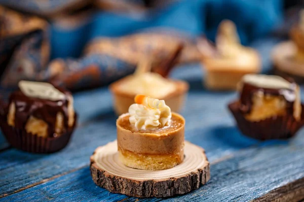 蛋糕与焦糖和坚果奶油在木质背景 — 图库照片