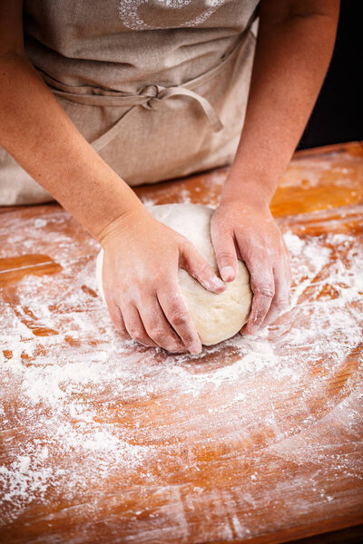 Female hands kneading and making bread dough