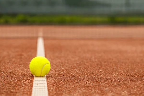 클레이 코트의 빨간색 표면에 테니스 공을의 클로즈업 — 스톡 사진