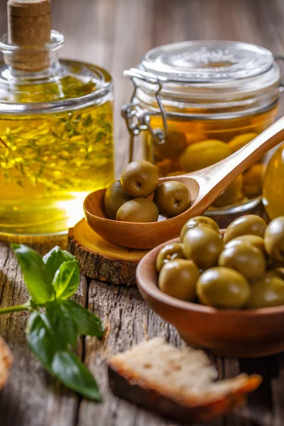 Grüne Oliven Und Olivenöl Auf Holzgrund — Stockfoto