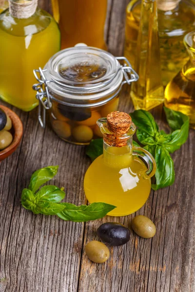 Glasflaschen Mit Olivenöl Und Beeren Auf Dem Holztisch — Stockfoto