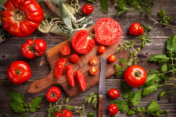 作为木菜板上的刀和番茄堆切割红西红柿组成背景 — 图库照片