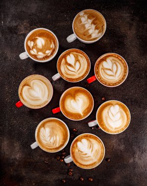 Sıcak kahve latte sanat üzerinde koyu arka plan ayarlamak daire yatıyordu