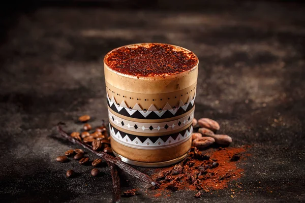 Winter coffee drink in glass spiced with cocoa powder and vanilla