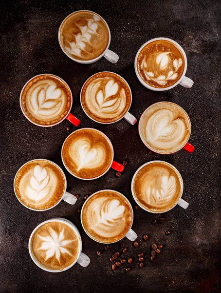 Flat lay of hot coffee latte art set on vintage dark background