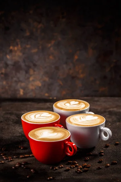 在黑暗的背景上喝咖啡 不同形状的拿铁艺术 — 图库照片
