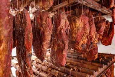 Tütsülenmiş domuz pirzolası fabrikası aynı anda büyük miktarlarda et tütsüleme odasında kancalarla yapılır.