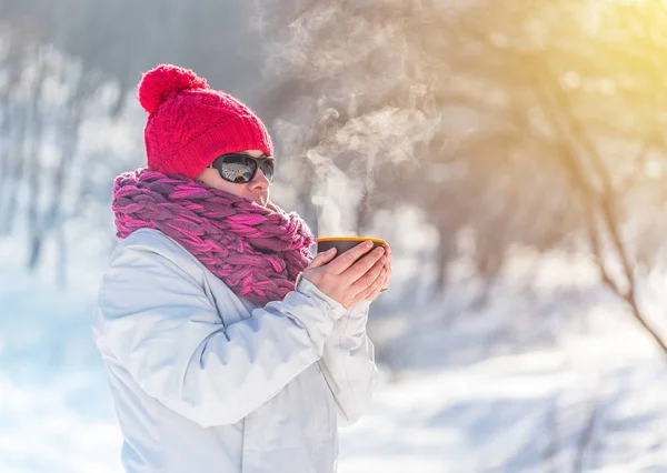 雪に覆われたフォレスト ビューの背景に熱いお茶を飲む女性 — ストック写真