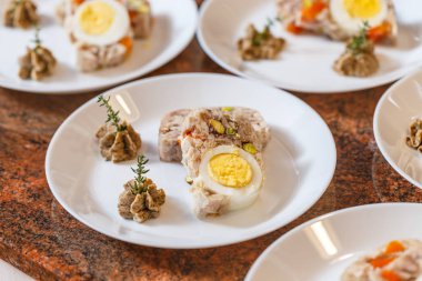 Yumurta ve beyaz tabakta sebze jöleli et