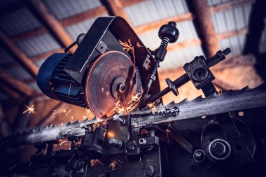 Yakın çekim sıcak uçan sparks bir çelik iş parçası testere ile kesme