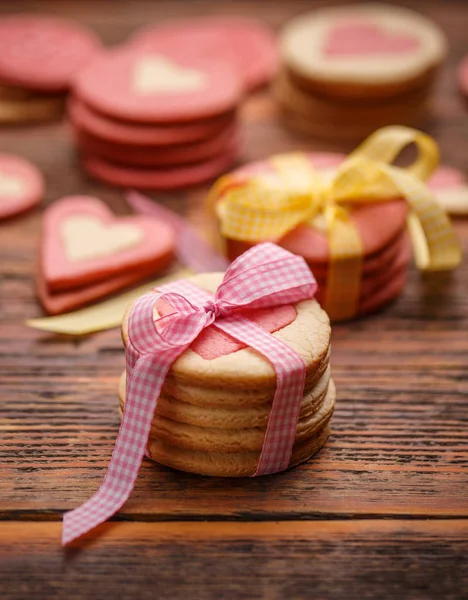 木製テーブルの上にピンクのリボンがバレンタインの日にクッキー — ストック写真