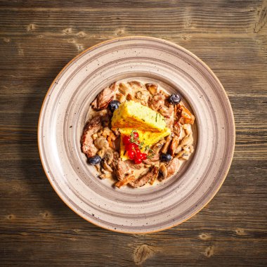 Düz ahşap zemin üzerine kavrulmuş polenta ile sığır eti bonfile güveç göklere