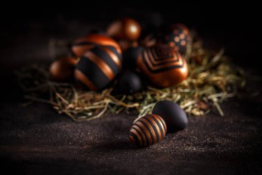 Altın ve siyah Paskalya yumurtaları koyu arka plan üzerinde çizgiler ile dekore edilmiştir. Tatil tebrik kartı