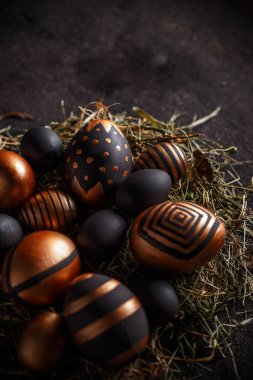 Yuvasında altın ve siyah yumurtalar olan Paskalya kompozisyonu