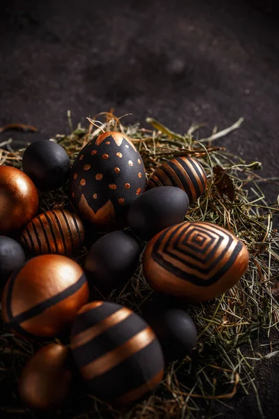 Yuvasında altın ve siyah yumurtalar olan Paskalya kompozisyonu