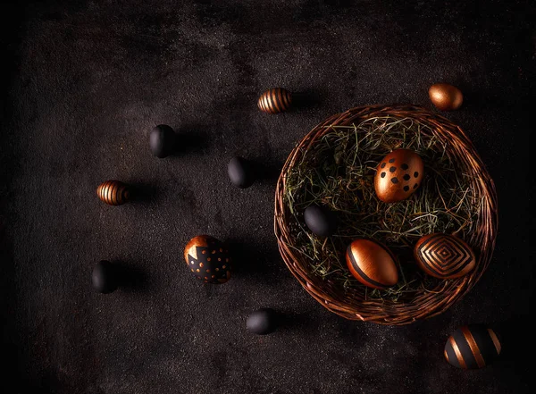 Siyah arka plan siyah ve altın yumurta. Düz yatıyordu 