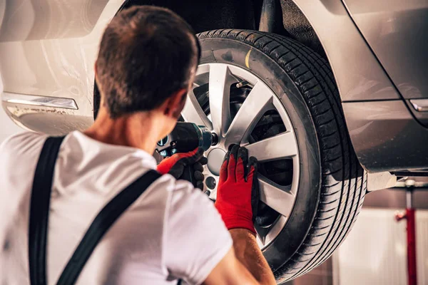 Técnico adulto ajustando pneus de carros — Fotografia de Stock