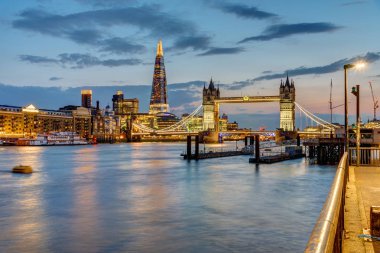 Tower Bridge ve arka parça ile güneş battıktan sonra Londra'da Thames Nehri görünümünü