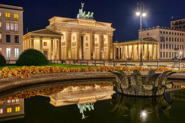 Híres Berlini Brandenburgi Kapu Éjjel Tükröződik Egy Szökőkútban — Stock Fotó