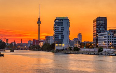 Berlin'de Spree nehrinde arkadaki ünlü Televizyon Kulesi ile dramatik gün batımı