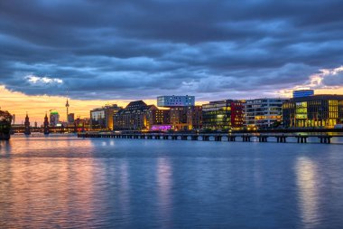 Arka ünlü Televizyon Kulesi ile Berlin'de nehir Spree güzel gün batımı