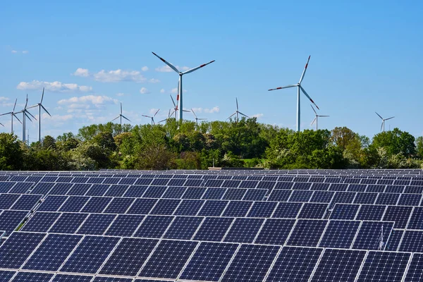 ドイツで見られる背面に風力タービンを備えた近代的な太陽光発電所 — ストック写真