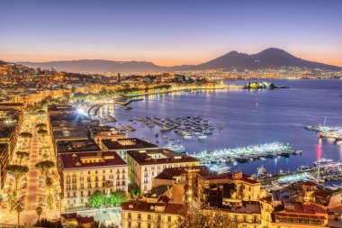 The city of Naples in Italy with Mount Vesuvius before sunrise clipart