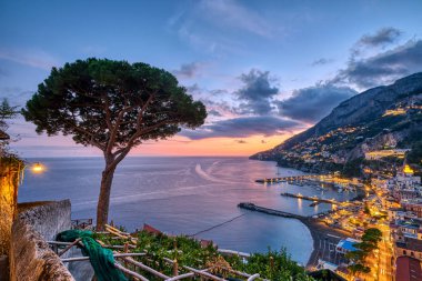 İtalya 'da gün batımından sonra yalnız bir çam ağacıyla Amalfi manzarası