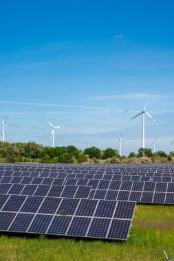 Almanya 'da arkasında rüzgar türbinleri olan güneş enerjisi panelleri görülüyor
