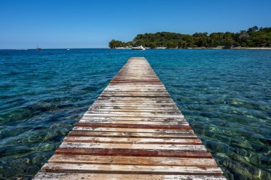 Hırvatistan 'ın Rovinj kenti yakınlarında turkuaz sularla eski ve yıpranmış bir iskele görülüyor