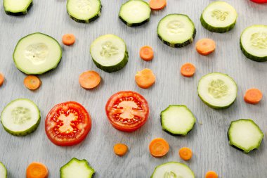 Ahşap bir masa üzerinde sağlıklı ürünlerin arka plan. Sebze - kabak, domates, salatalık, havuç üstten görünüm.