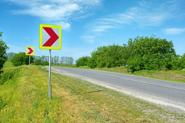 田舎道で危険なターンの警告サイン — ストック写真