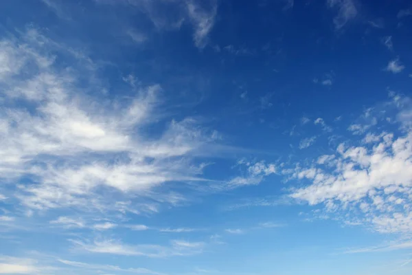 Witte cirruswolken tegen de donker blauwe hemel. — Stockfoto