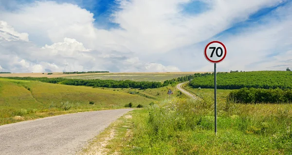 Verkeersbord beperkende snelheid op landweg. — Stockfoto