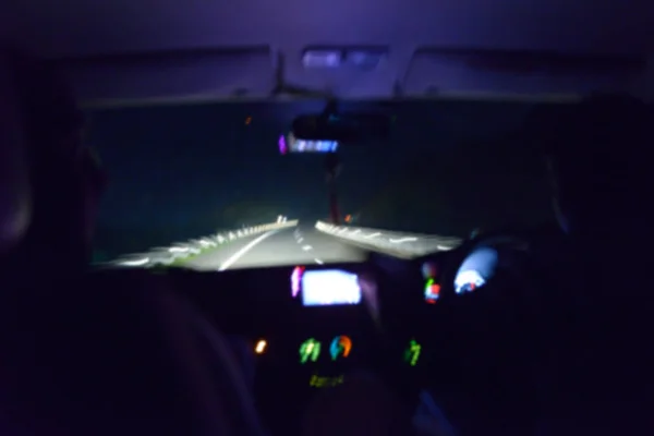 Photo de nuit floue à l'intérieur de la voiture avec chauffeur . — Photo