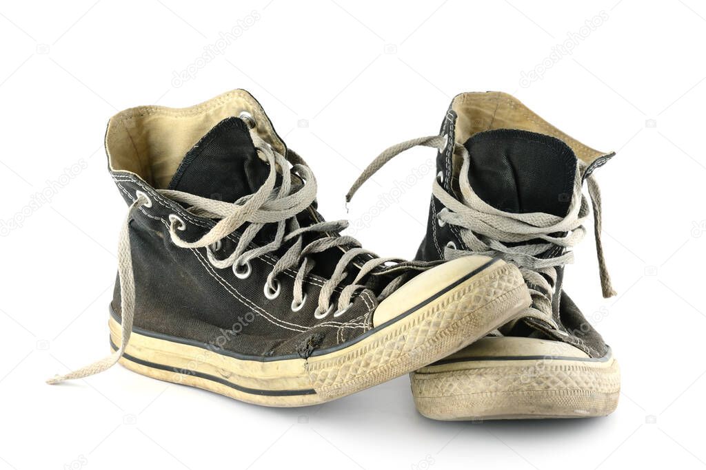 Old faded and worn sneakers isolated on white background