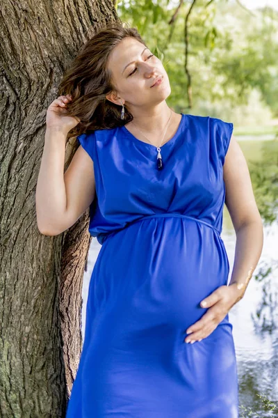Młoda Kobieta Ciąży Niebieskiej Sukience Spaceru Parku — Zdjęcie stockowe