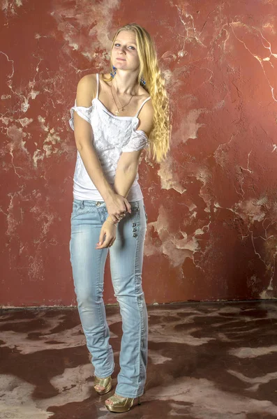 Genç sarışın kız kot ve beyaz bir kazak